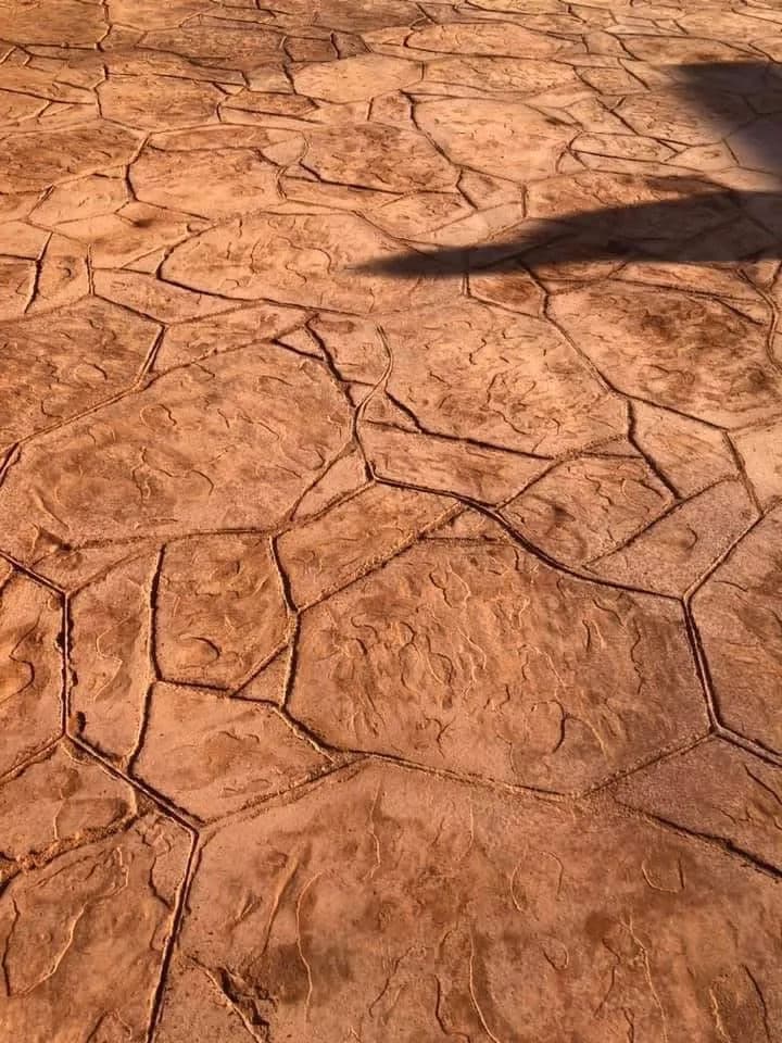 textured brown stone pavement with hexagonal patterns and shadows on the surface