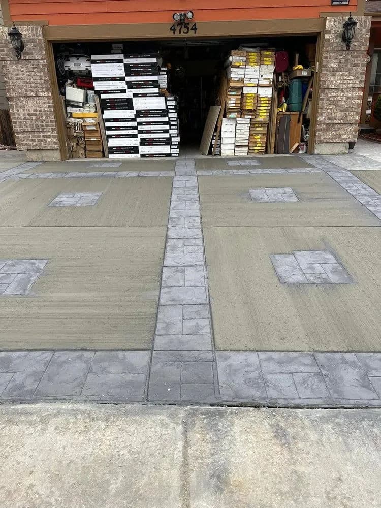 Decorative stamped concrete driveway with contrasting gray border and finishing detail.