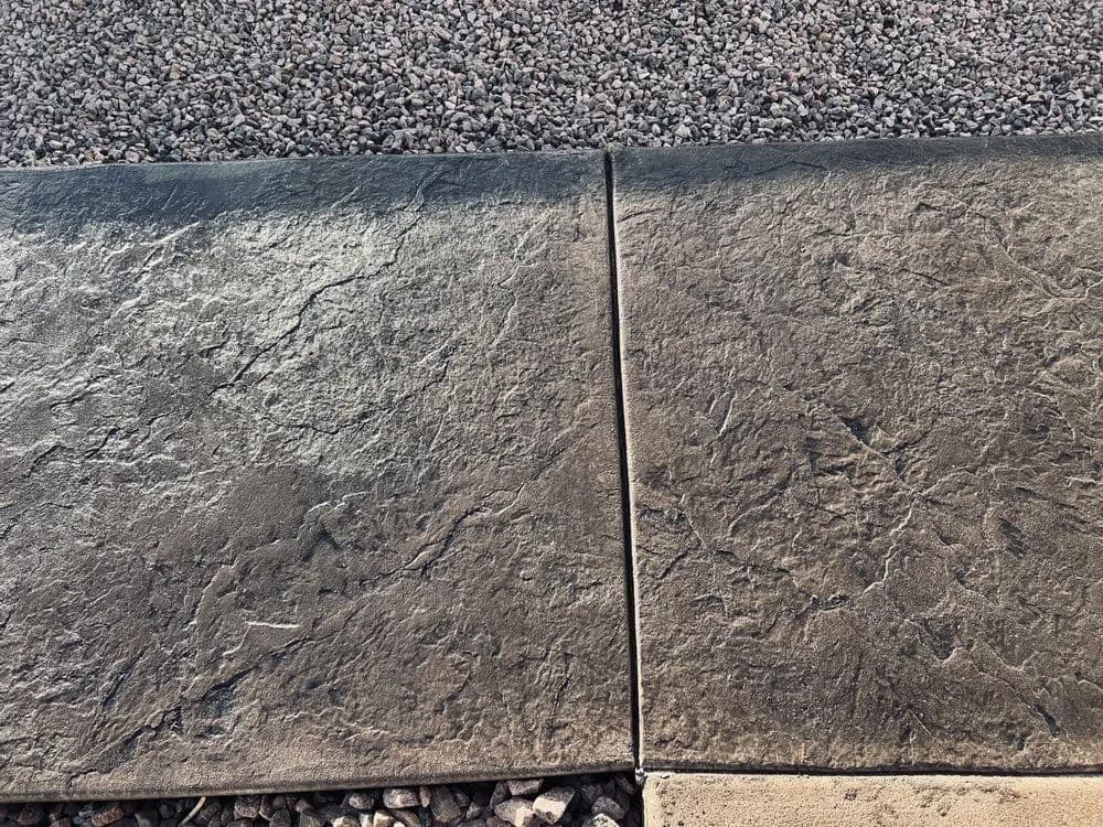 Textured concrete walkway with gravel border, showcasing detailed surface patterns.